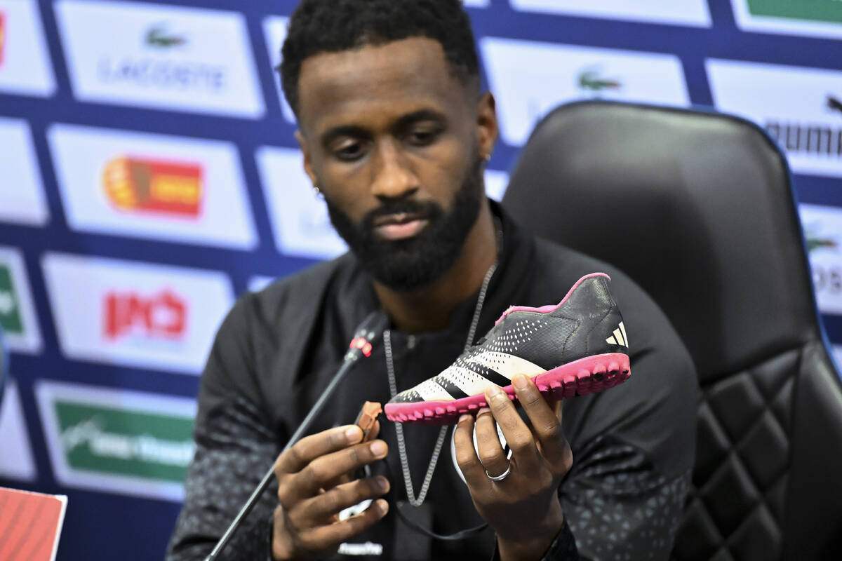 Israel team captain Eli Dasa shows a shoe of a kidnapped Israeli boy during a press conference, ...