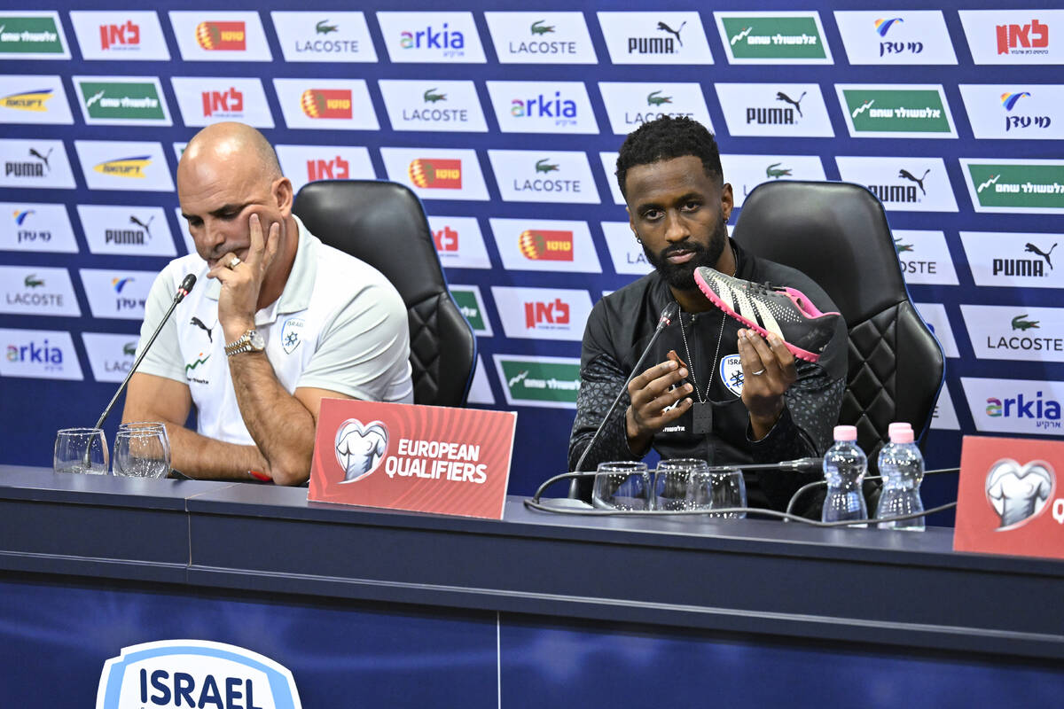 Israel team captain Eli Dasa, right, sits by head coach Alon Hazan as he shows a shoe of a kidn ...