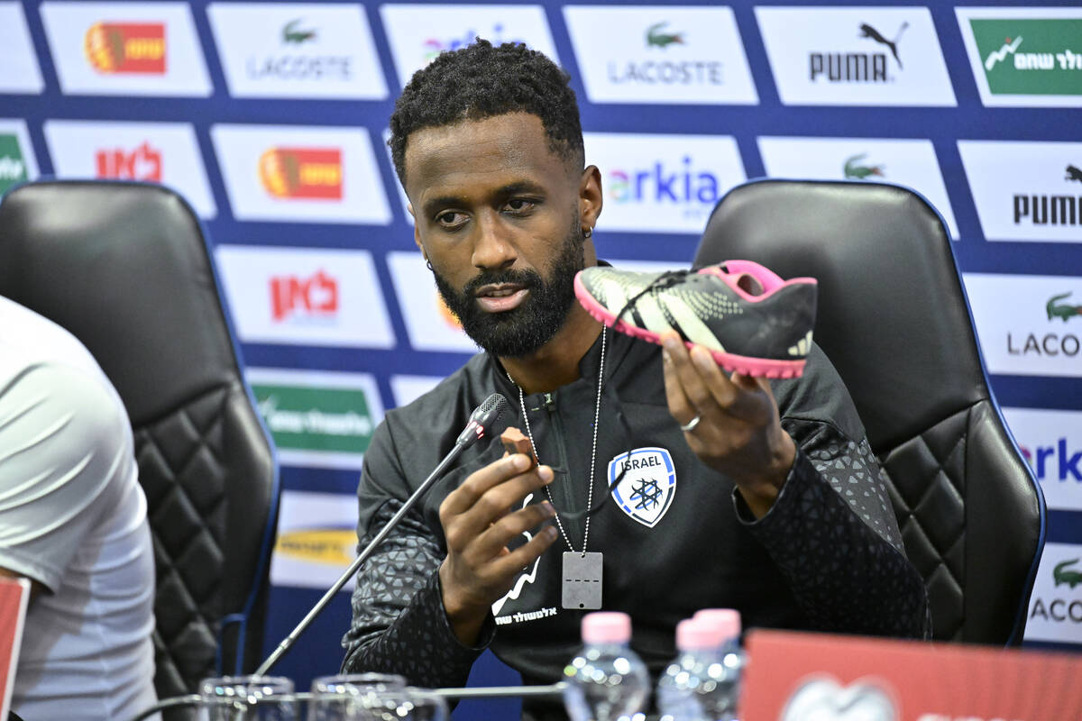 Israel team captain Eli Dasa shows a shoe of a kidnapped Israeli boy during a press conference, ...