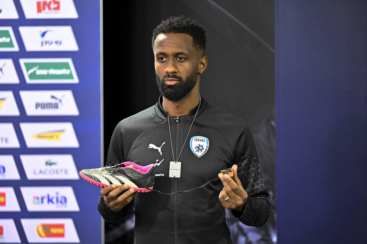 Israel team captain Eli Dasa shows a shoe of a kidnapped Israeli boy during a press conference, ...