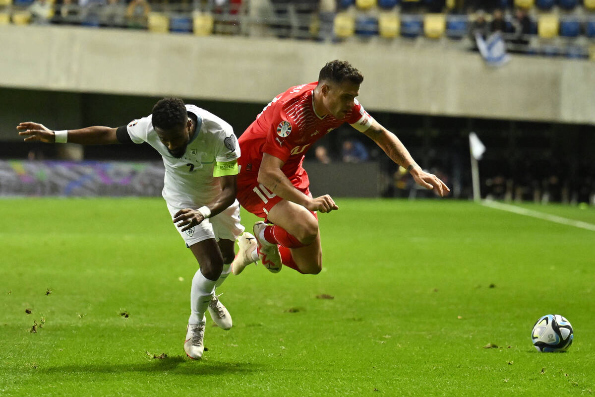 Israel's Eli Dasa, left, challenges Switzerland's Granit Xhaka during the Euro 2024 group I qua ...