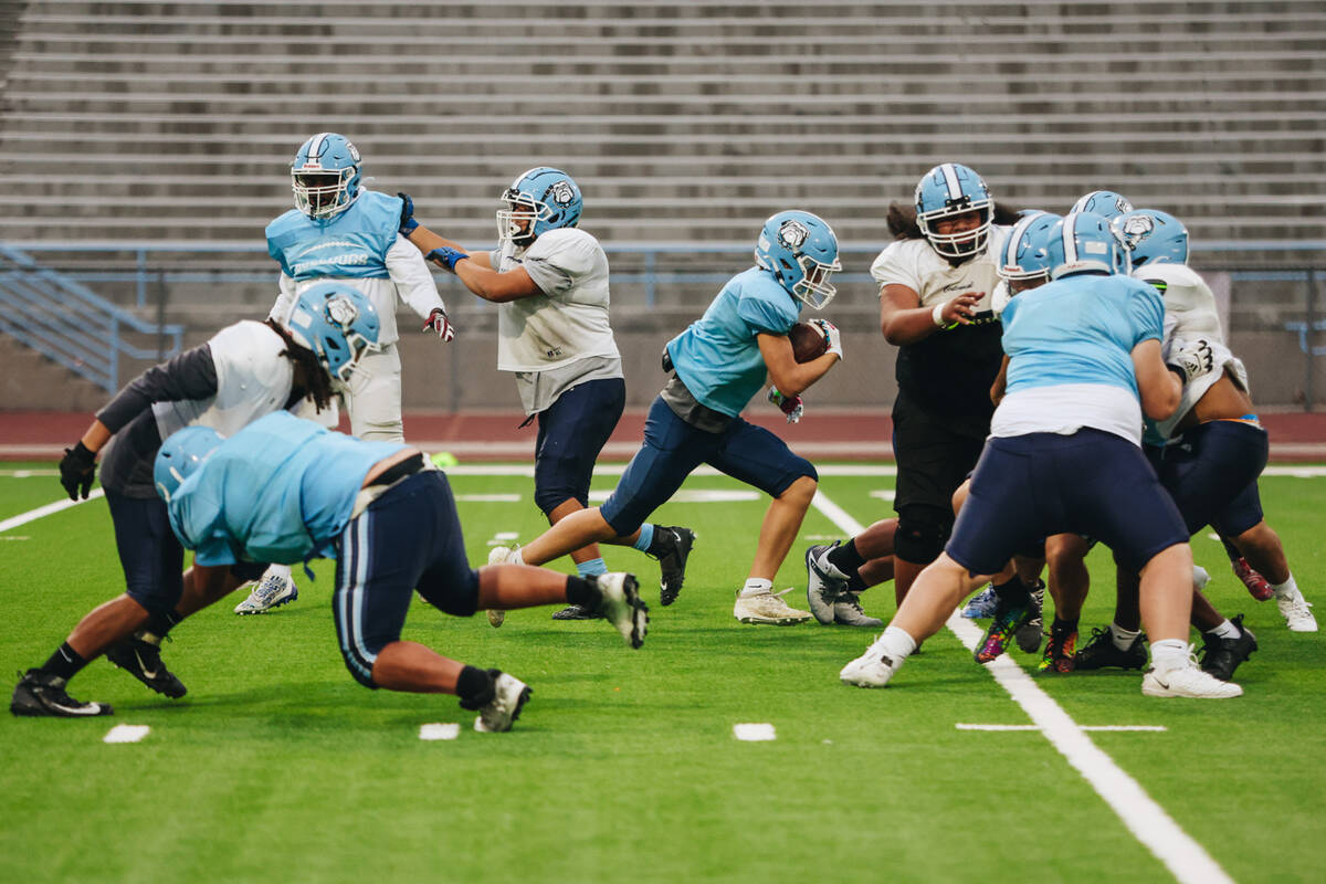 Centennial football players participate in a team practice at Centennial High School on Wednesd ...