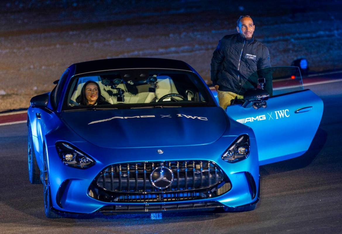 Mercedes-AMG driver Lewis Hamilton stands beside a new GT after a drone show during the Mercede ...