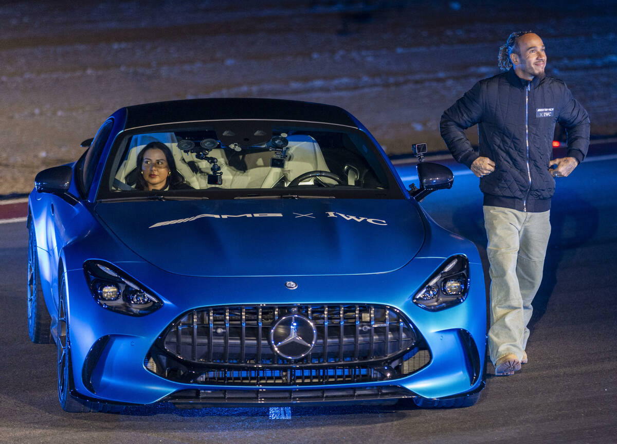 Mercedes-AMG driver Lewis Hamilton stands beside a new GT after a drone show during the Mercede ...