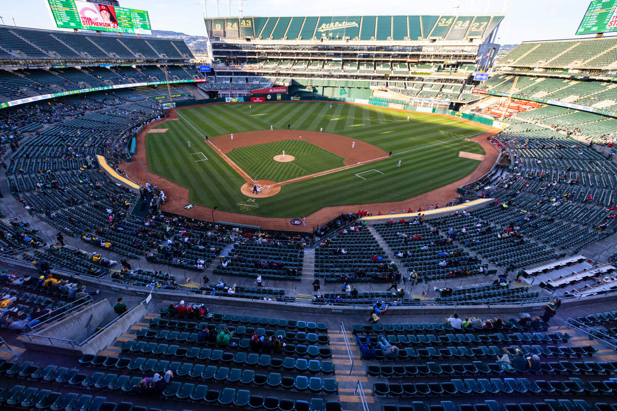 Fans watch a baseball game between the A’s and the Cincinnati Reds at the Oakland Colise ...