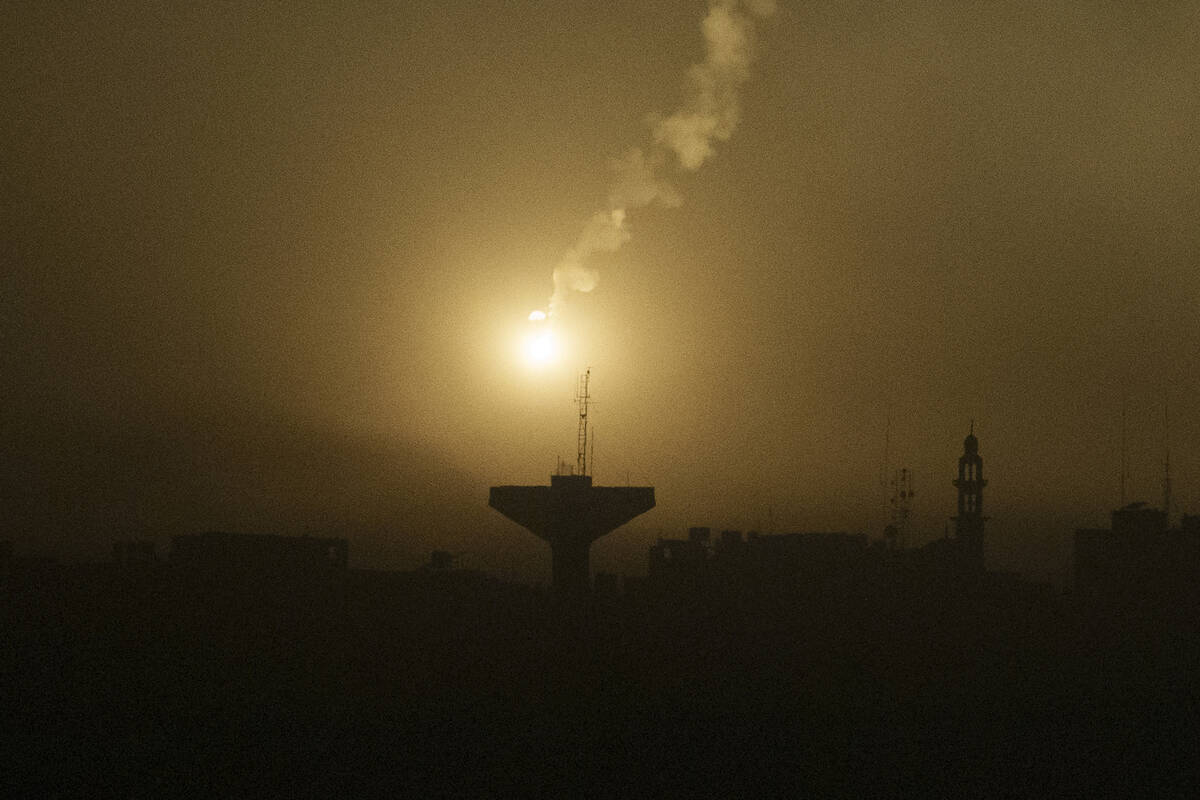 A flare drifts over the Gaza Strip as it illuminates the nigh sky, as seen from southern Israel ...