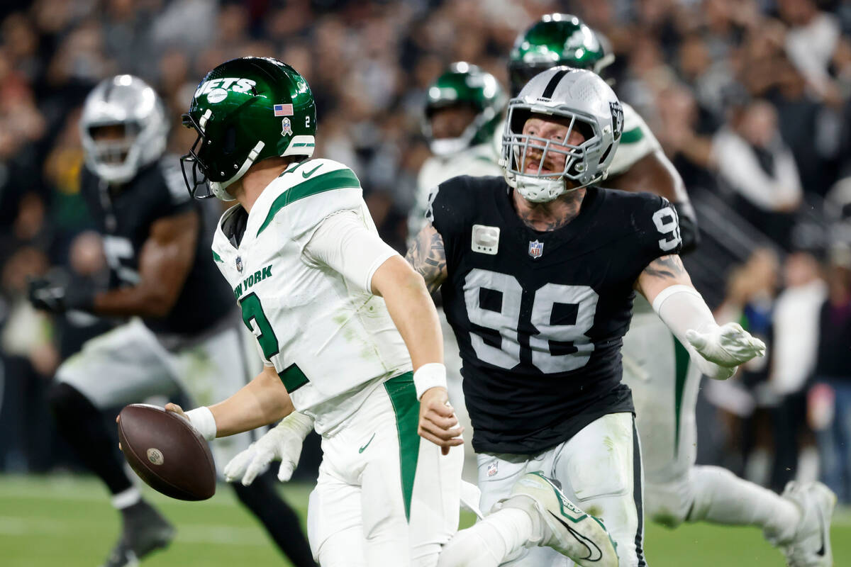 New York Jets quarterback Zach Wilson (2) is chased by Raiders defensive end Maxx Crosby (98) d ...