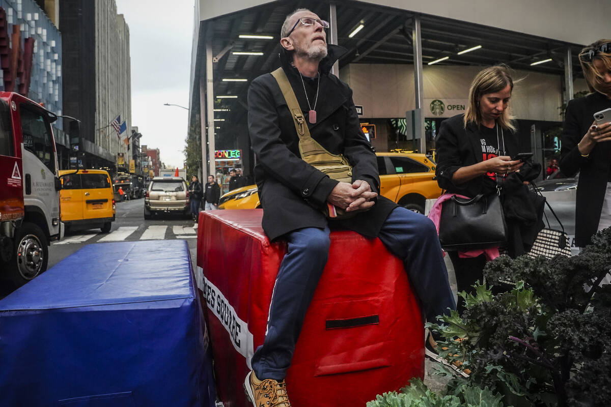 Thomas Hand, 63, looks up at a Times Square digital billboard where a poster of his daughter Em ...