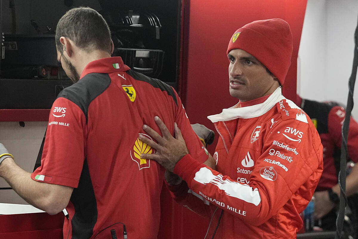 Ferrari driver Carlos Sainz, of Spain, talks with his a team member before the final practice s ...