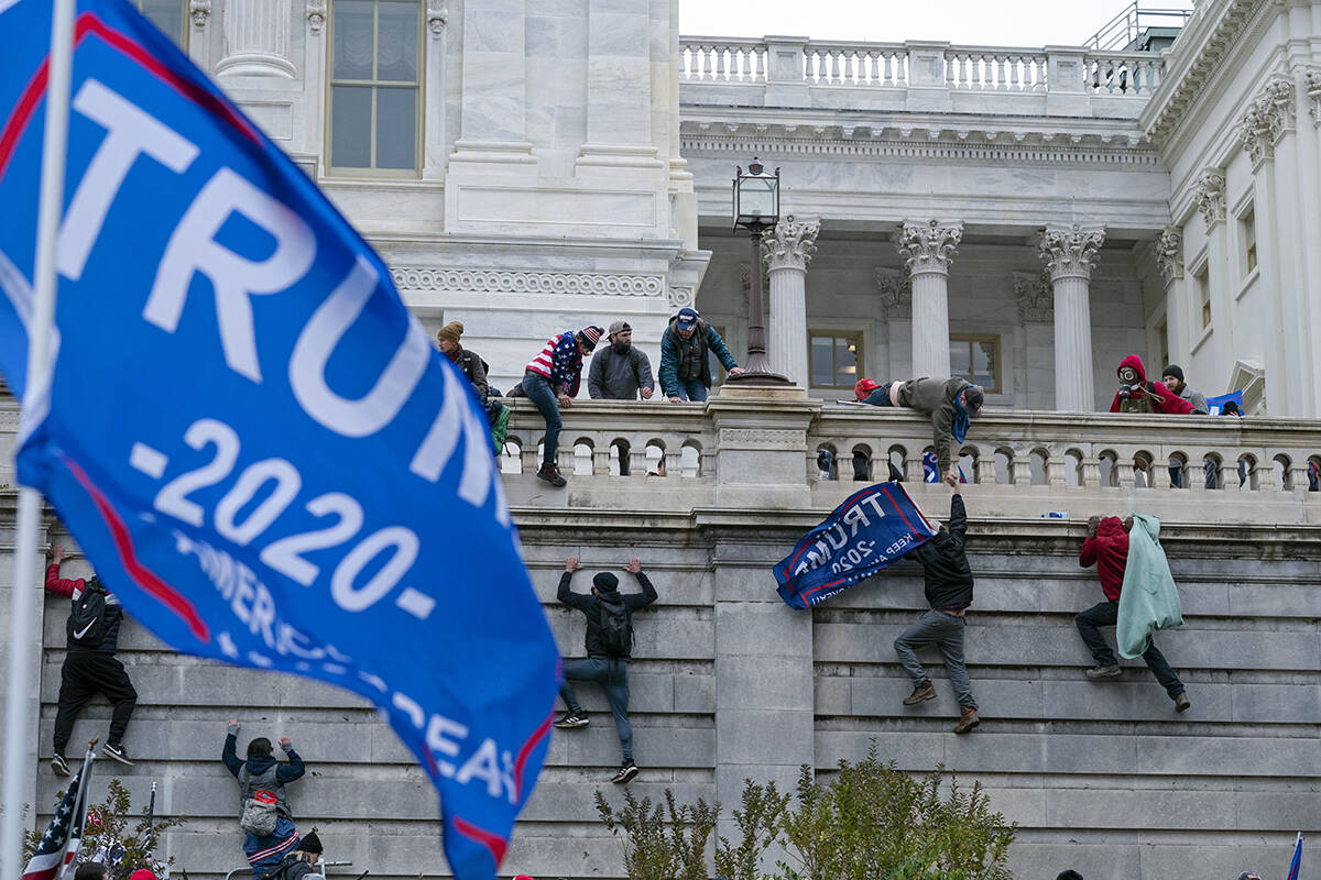 Support of President Donald Trump climb the West wall of the the U.S. Capitol on Wednesday, Jan ...