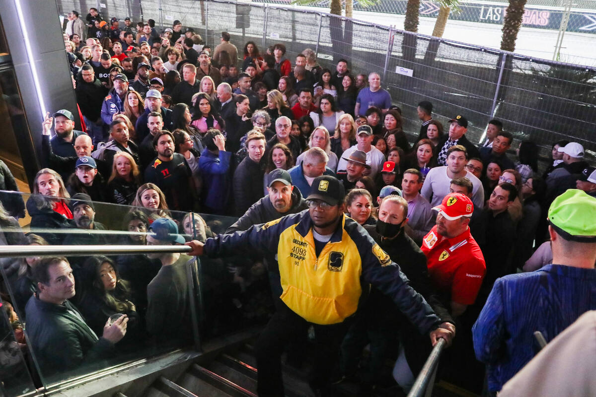 A security guard holds back a hard of people prior to the final Formula 1 Las Vegas Grand Prix ...