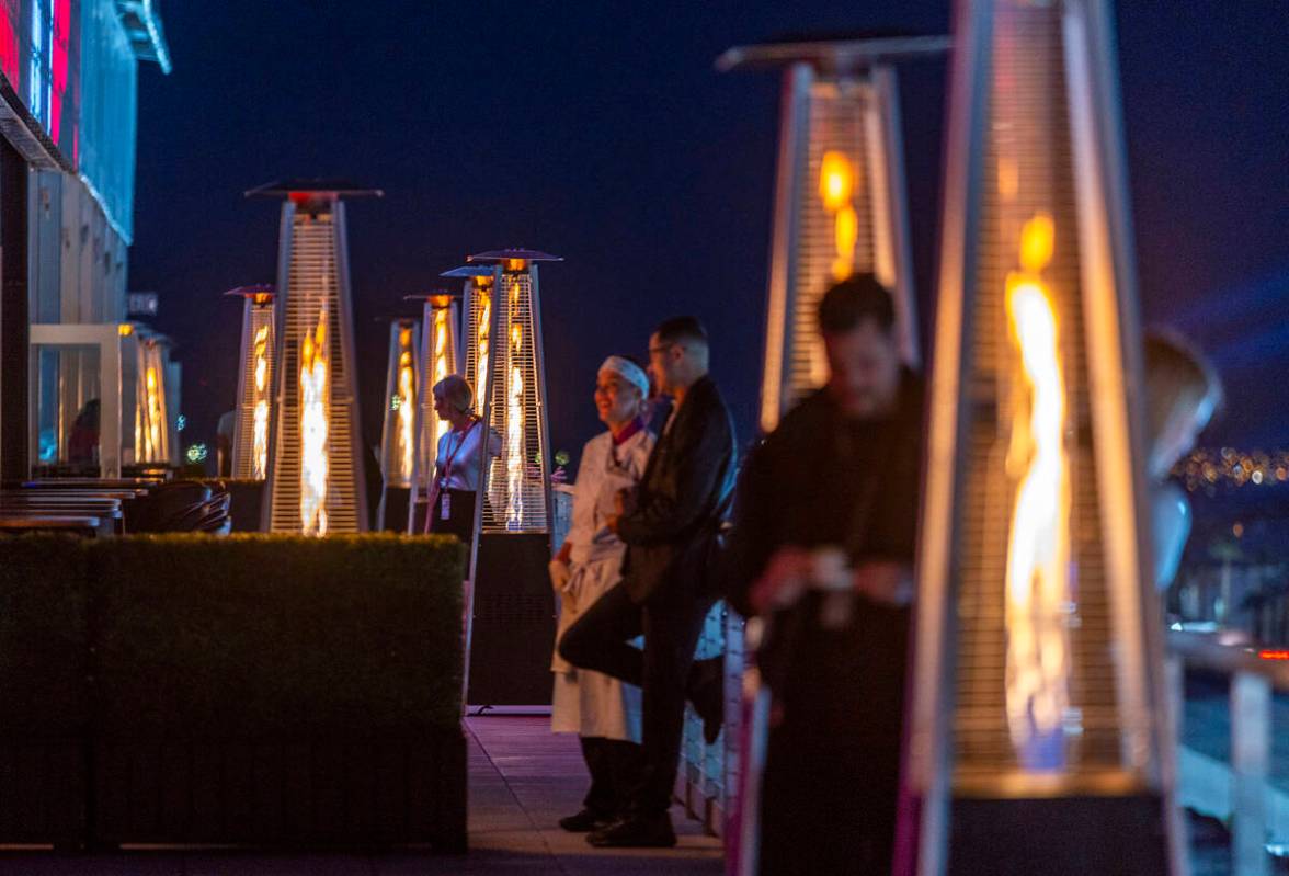 Heat lamps keep people warm on the paddock roof during on the final night of the Las Vegas Gran ...