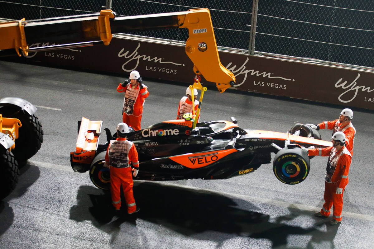 Crews flip the car of McLaren driver Lando Norris after he crashed during the final Formula 1 L ...