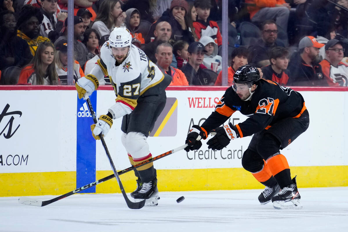 Vegas Golden Knights' Shea Theodore, left, gets the puck past Philadelphia Flyers' Noah Cates d ...