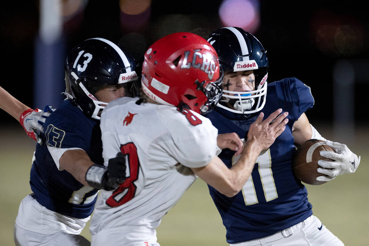 Lake Mead wide receiver Bowe Farmer (11) carries the ball while his teammates Brandon Quaglio ( ...