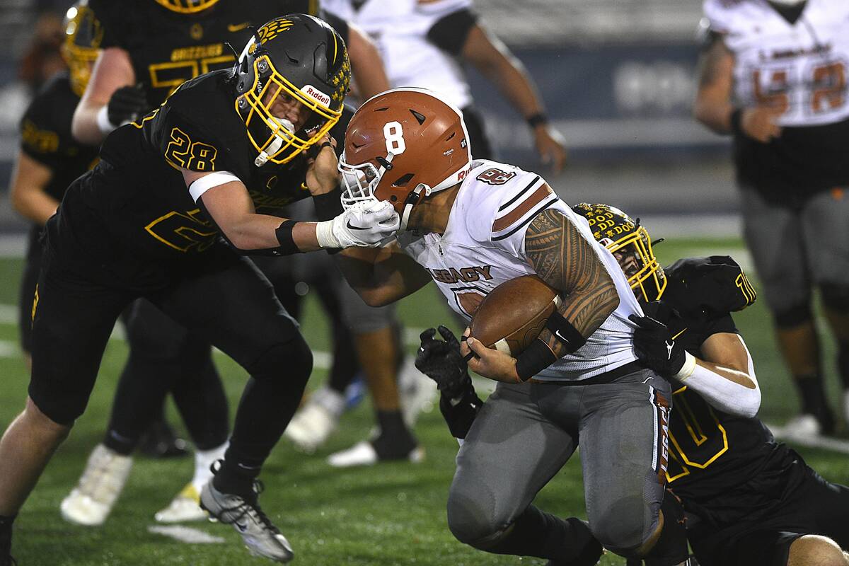 Legacy’s Phoenix Jennings gets his face mask grabbed by Galena’s Ever Whitaker during their ...