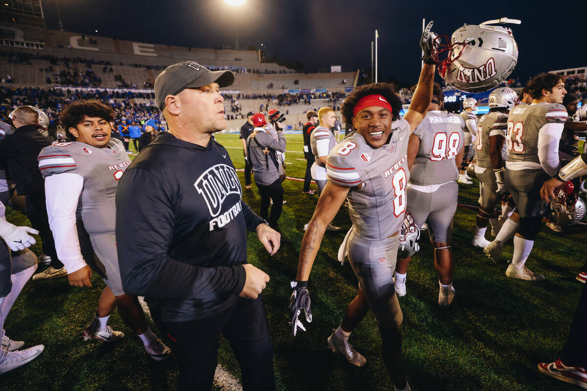 UNLV defensive lineman Darius Johnson (8) celebrates as he walks next to UNLV head coach Barry ...