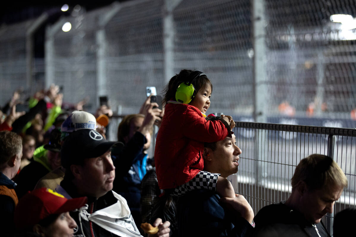 Fans watch drivers rounds the circuit before the Formula One Las Vegas Grand Prix auto race on ...