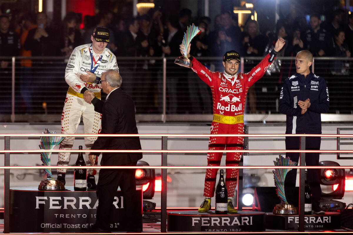 Red Bull Racing driver Sergio Perez holds up his third place trophy alongside his fellow winner ...