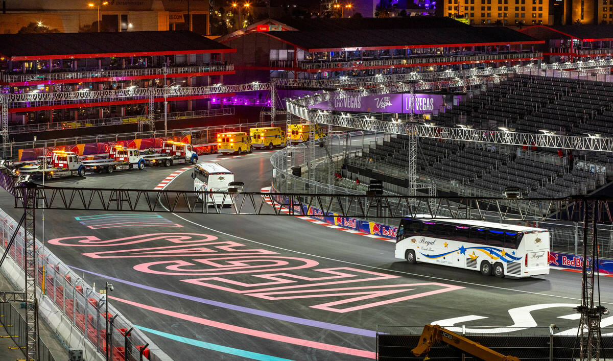 Busses round turn three passing emergency vehicles staged there during race night of the Las Ve ...