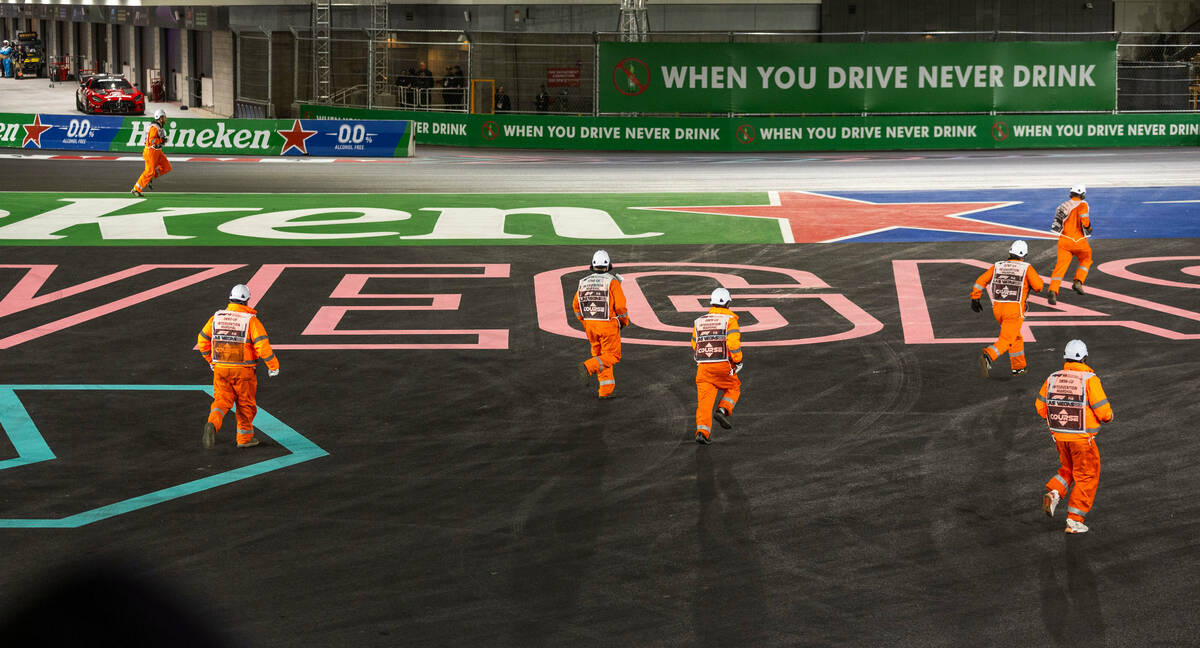 Intervention marshals run onto the course to pick up crash debris in turn one during the Las Ve ...