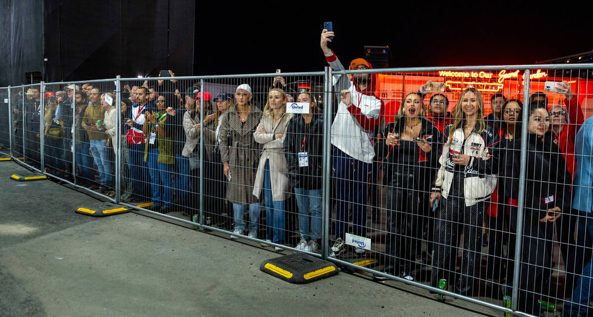 Fans watch the race from behind a fence near turn one during the Las Vegas Grand Prix Formula O ...