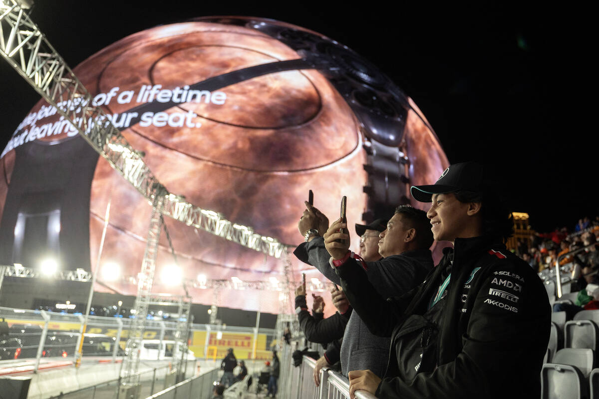 Formula One fans record the drivers parade before the Las Vegas Grand Prix auto race on Saturda ...