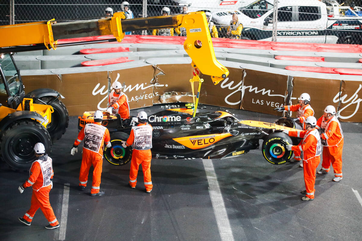 Crews flip the car of McLaren driver Lando Norris after he crashed during the final Formula 1 L ...