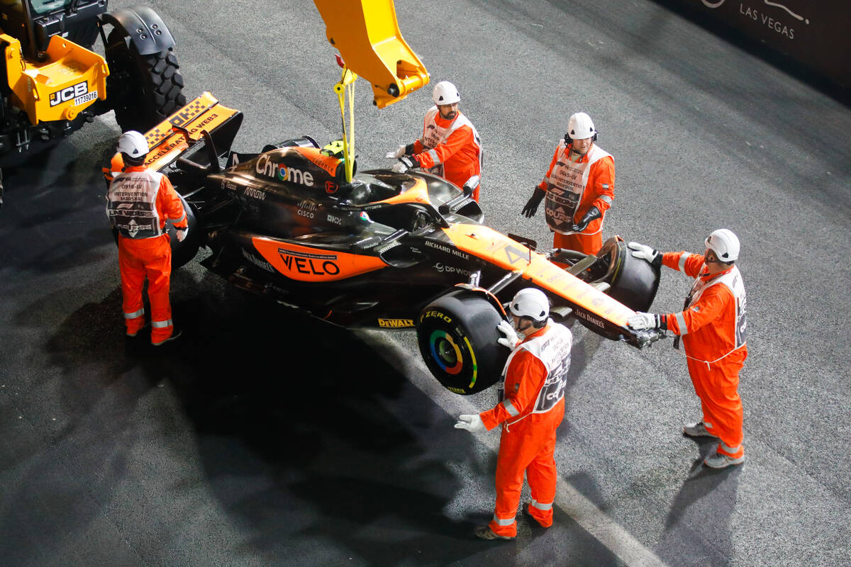 Crews flip the car of McLaren driver Lando Norris after he crashed during the final Formula 1 L ...