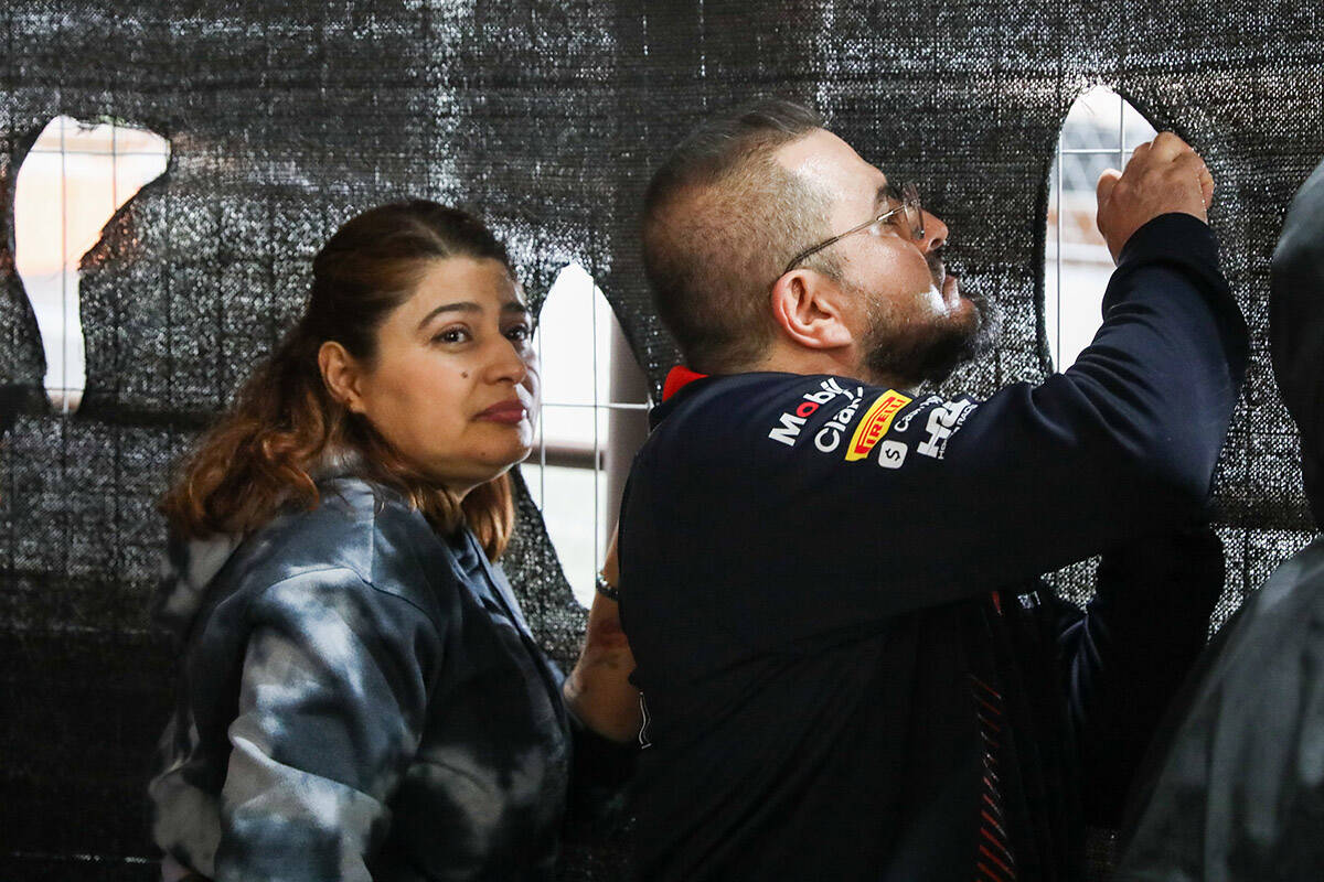 Fans cut holes into a fence netting to watch the final Formula 1 Las Vegas Grand Prix race on S ...