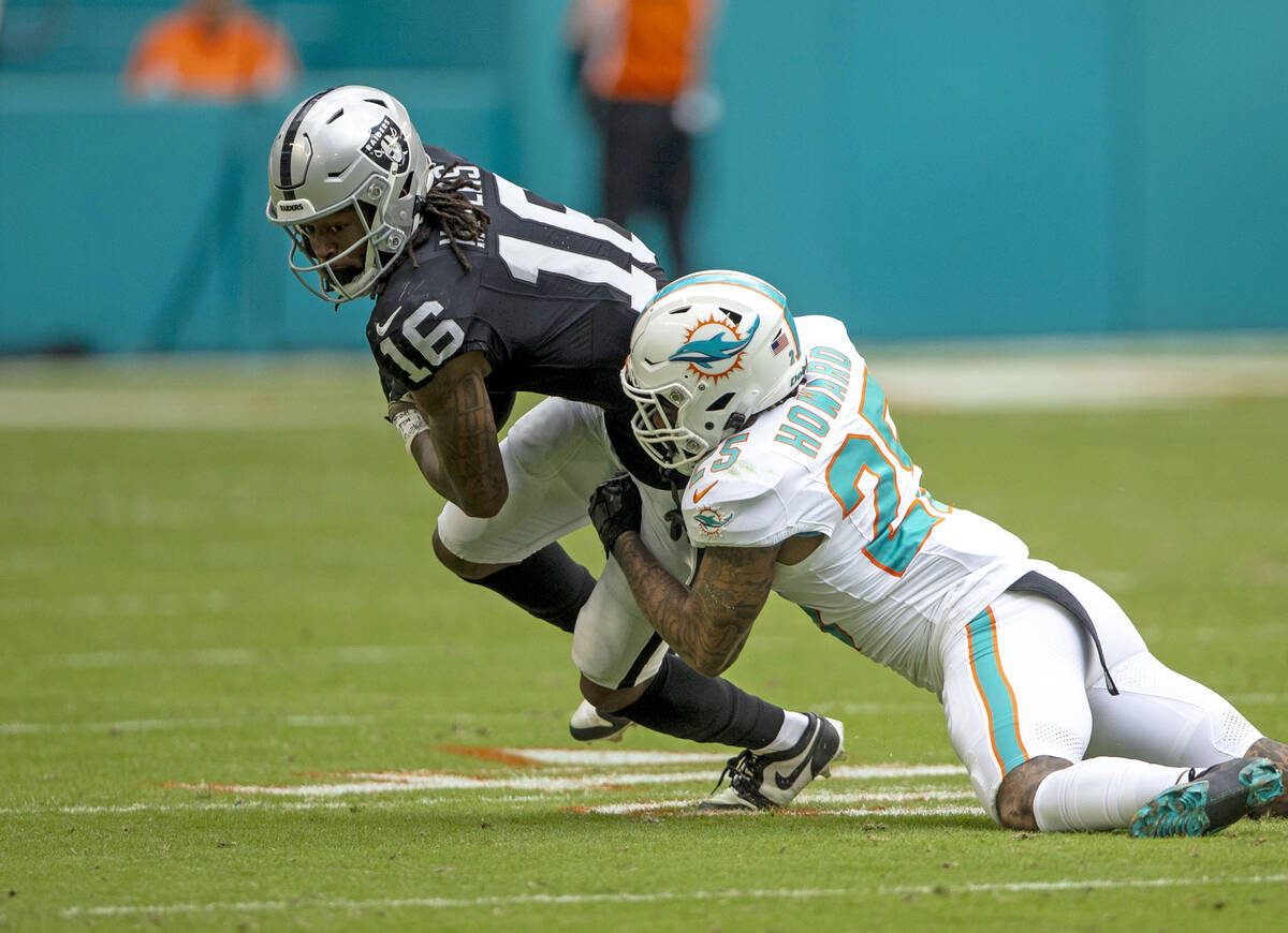 Raiders wide receiver Jakobi Meyers (16) is brought down by Miami Dolphins running back Jeff Wi ...
