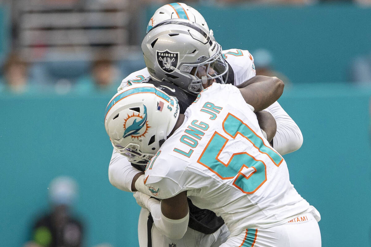 Raiders running back Josh Jacobs (8) is stopped by Miami Dolphins linebacker Bradley Chubb (2) ...