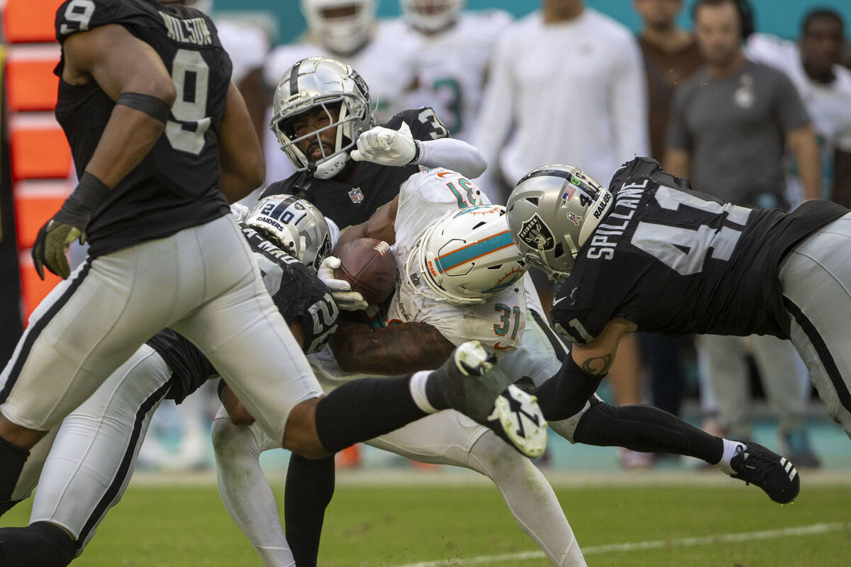 Miami Dolphins running back Raheem Mostert (31) is tackled by Raiders safety Isaiah Pola-Mao (2 ...