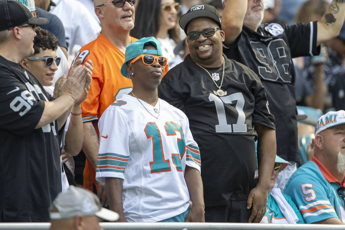 A Miami Dolphins fan and Raiders fan interact after Raiders wide receiver Davante Adams’ ...