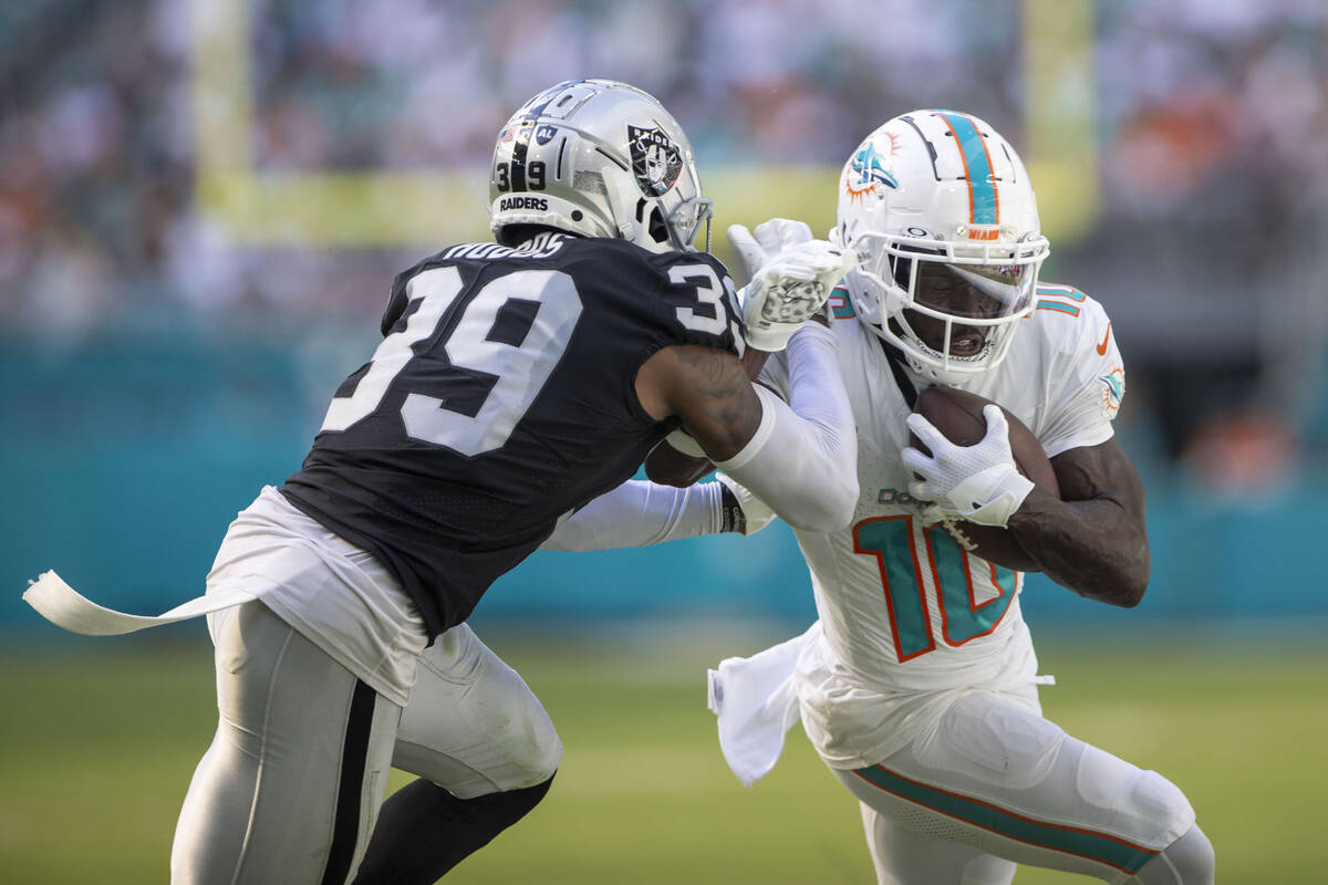 Miami Dolphins wide receiver Tyreek Hill (10) works to get past Raiders cornerback Nate Hobbs ( ...
