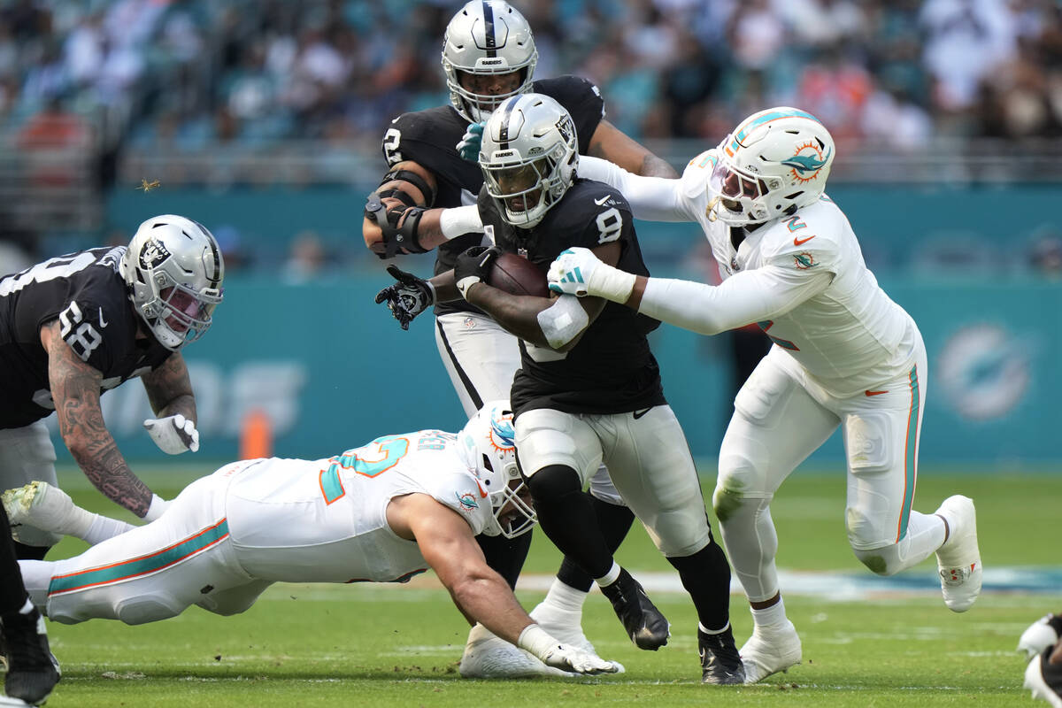Las Vegas Raiders defensive end Tyree Wilson (9) is tackled by Miami Dolphins linebacker Bradle ...