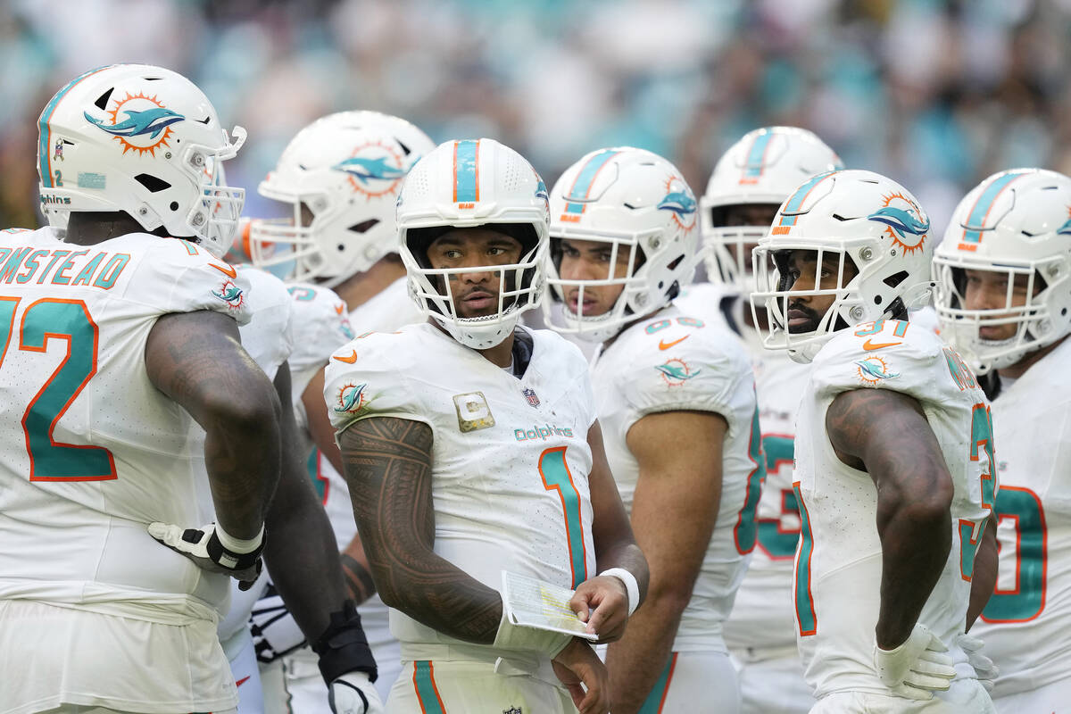 Miami Dolphins quarterback Tua Tagovailoa (1) listens to offensive tackle Terron Armstead (72) ...