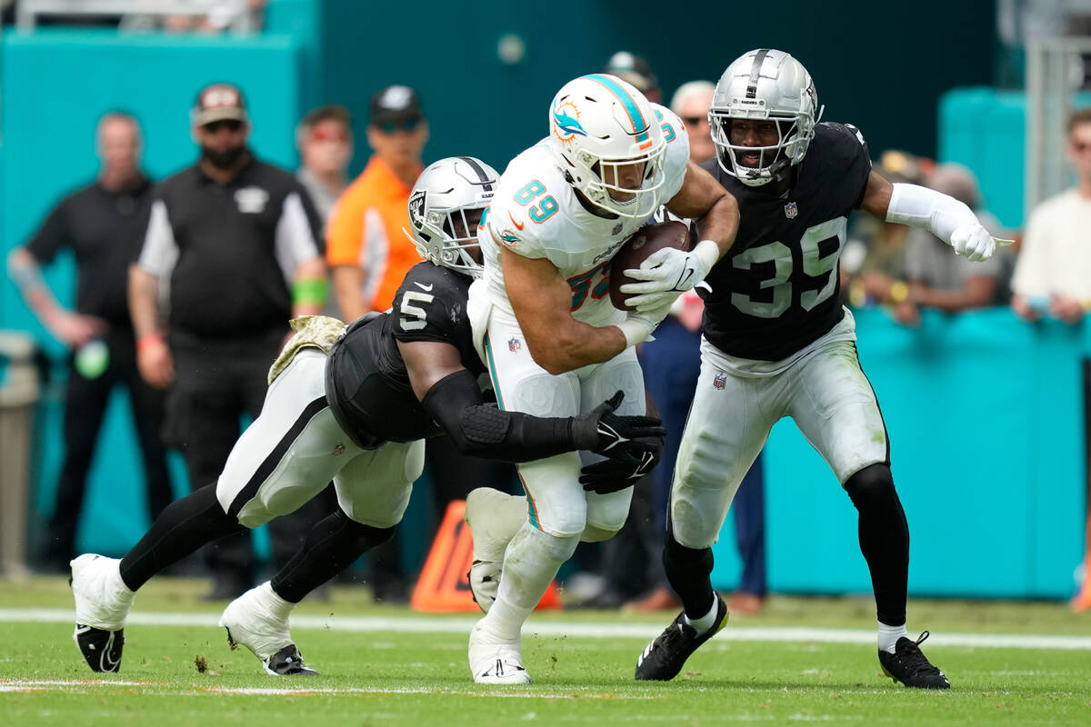 Las Vegas Raiders cornerback Nate Hobbs (39) and linebacker Divine Deablo (5) pressure Miami Do ...