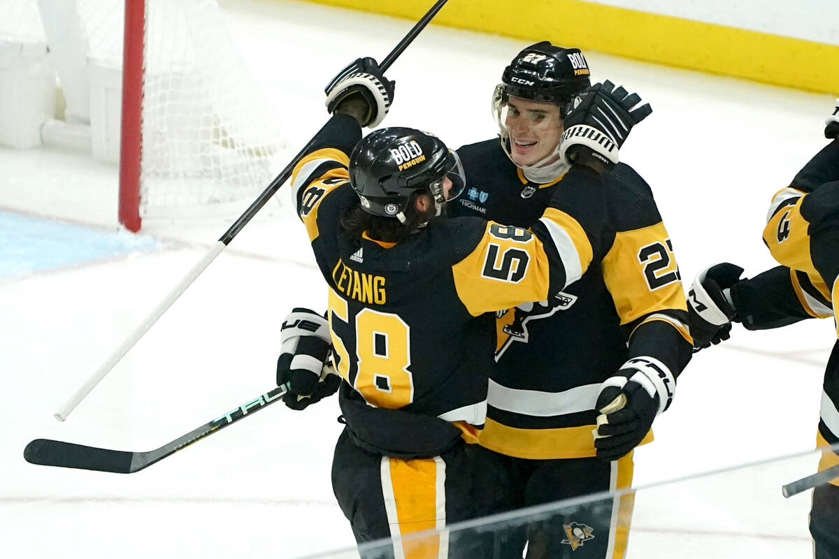 Pittsburgh Penguins' Ryan Graves is congratulated by Kris Letang for a goal against the Vegas G ...