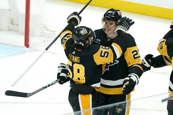 Pittsburgh Penguins' Ryan Graves is congratulated by Kris Letang for a goal against the Vegas G ...