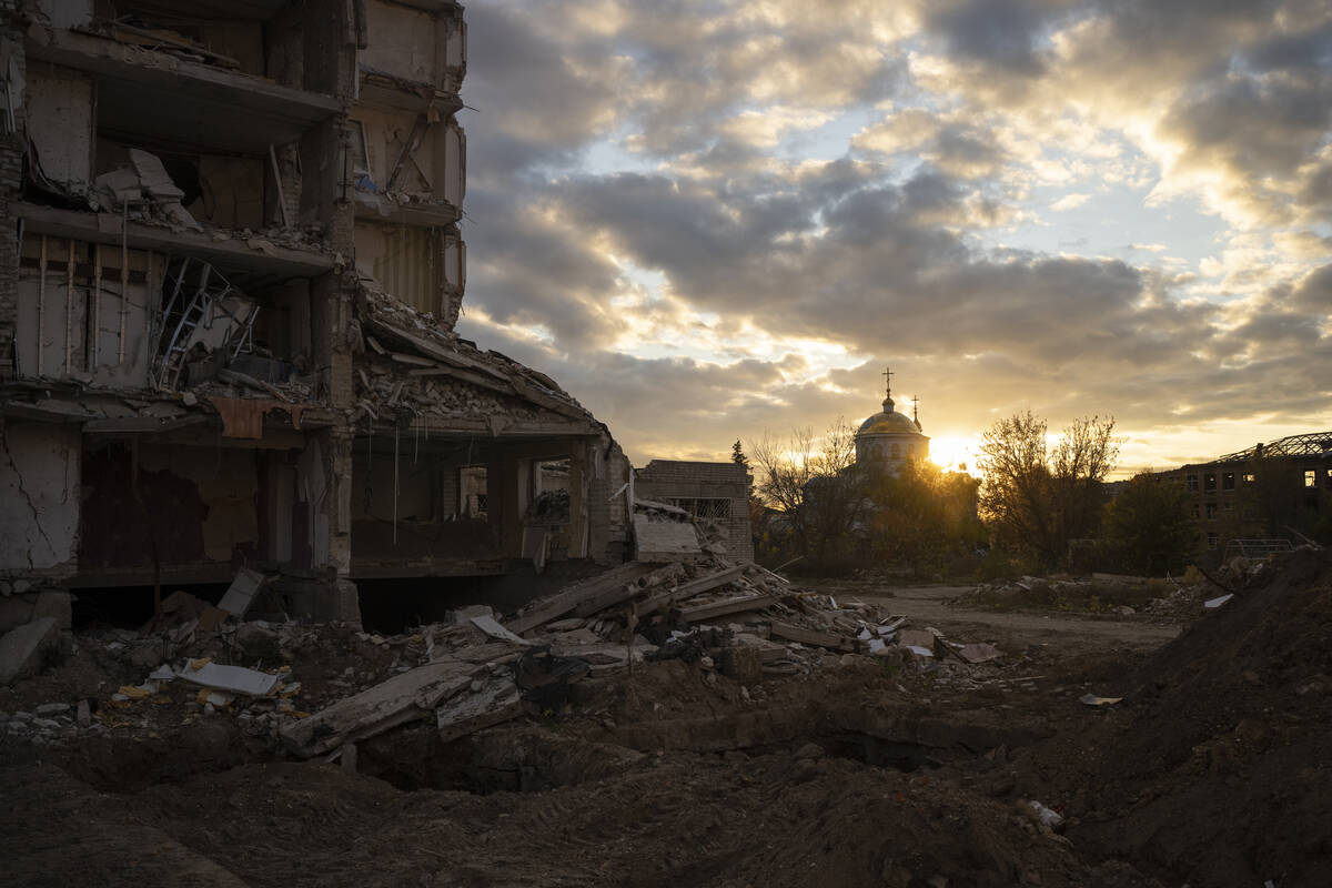 The sun sets over a destroyed building in Izyum, Ukraine, Tuesday, Oct. 24, 2023. (AP Photo/Bra ...