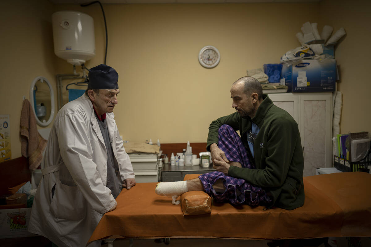 Ukrainian doctor Yurii Kuznetsov speaks to land mine victim Oleksandr Kolisnyk at the hospital ...