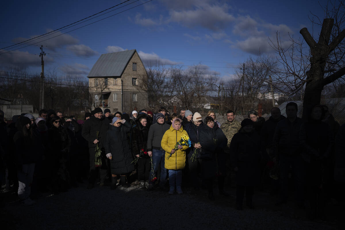 People pay respect as the coffin containing the body of Serhii Havryliuk, 48, passes by during ...