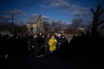 People pay respect as the coffin containing the body of Serhii Havryliuk, 48, passes by during ...