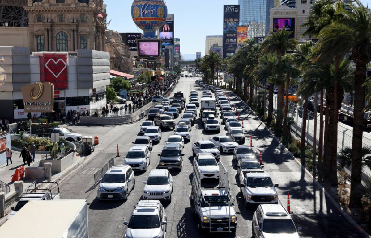 Cars make their way up the Strip near Flamingo Road as crews remove fencing an barriers for the ...