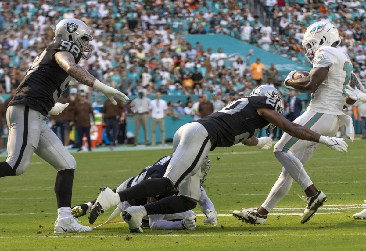 Raiders safety Isaiah Pola-Mao (20) stops Miami Dolphins wide receiver Tyreek Hill (10) on a fo ...