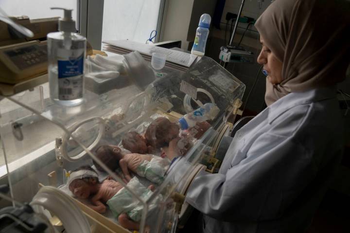 A nurse prepares premature babies for transport to Egypt after they were evacuated from Shifa H ...