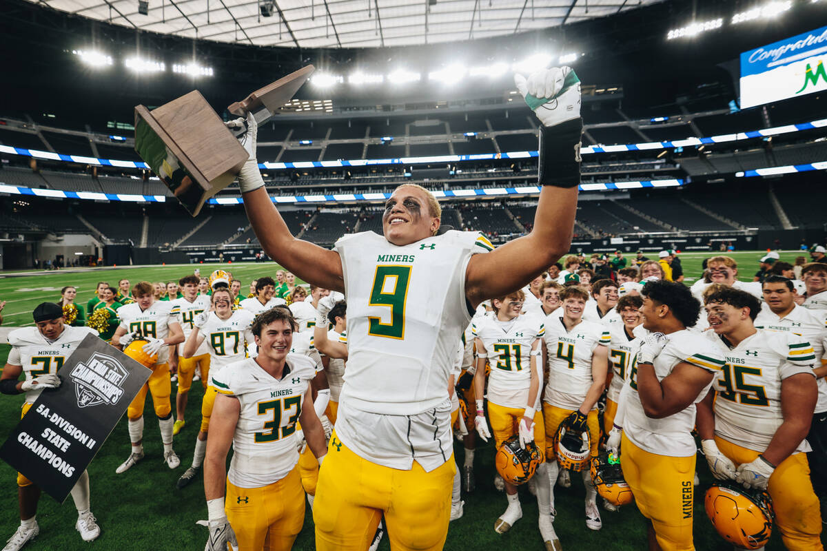 Bishop Manogue linebacker Marrio (cq) Williams Jr. (9) celebrates with a state championship tro ...