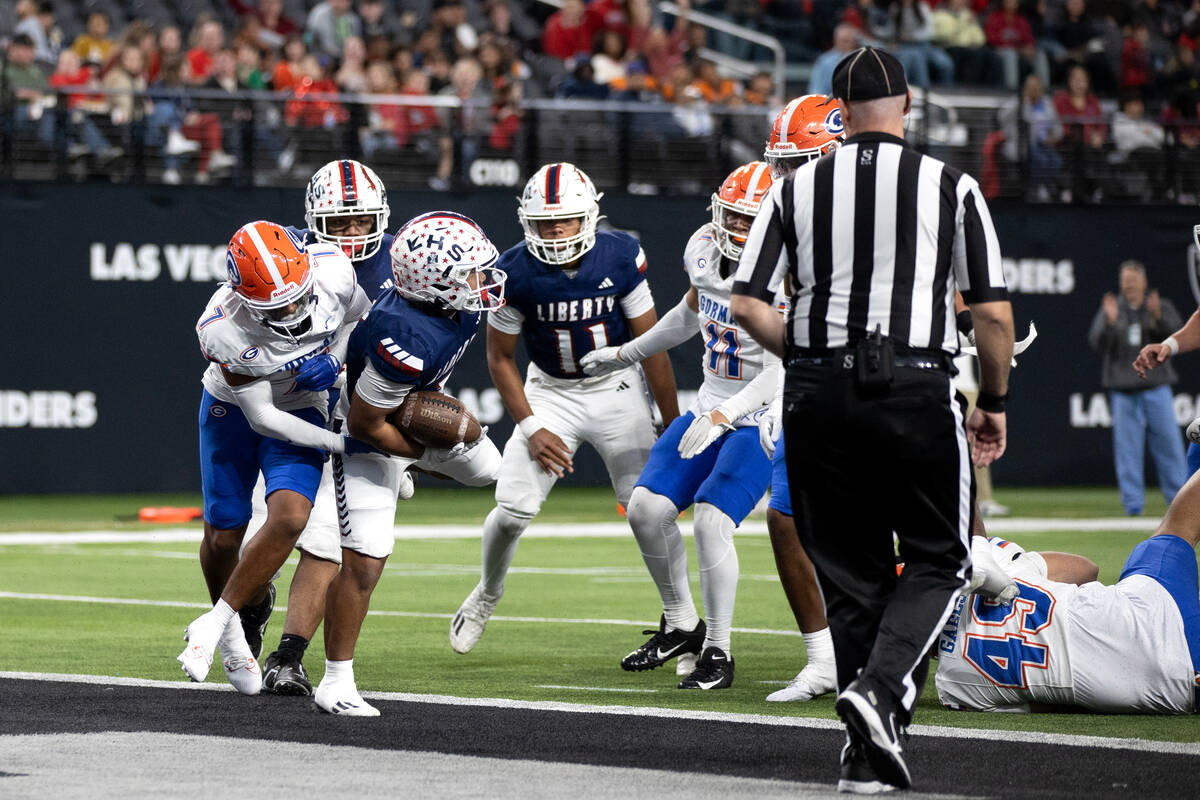 Liberty running back Isaiah Lauofo (3) scores a touchdown while Bishop Gorman’s Marco C ...