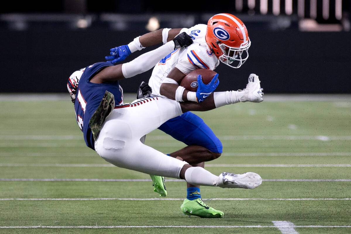 Bishop Gorman running back Devon Rice (3) runs through an attempted tackle by Liberty linebacke ...